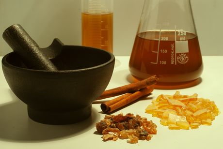 Replicating the Mendesian perfume (counterclockwise from top left): a measuring cylinder with desert date oil (Balanites aegyptiaca), mortar and pestle, myrrh (Commiphora myrrha), pine resin (Pinus sp.), cinnamon cassia quills, completed perfume in a flask.